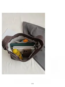 Vista dall'alto della spaziosa borsa tote marrone scuro che mostra l'interno per tablet e libri