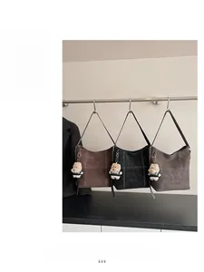 Dettaglio della grande borsa tote vintage con lettere sbalzate e ciondolo a forma di orso