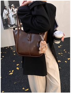 Dark brown faux leather underarm tote bag with plush puppy pendant and vertical stitching