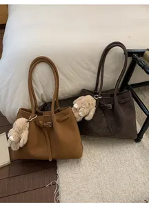 Detail view of large tote bags in light brown and dark coffee with plush rabbit charms