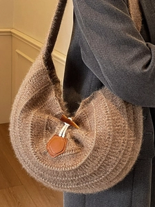 Brown knit crescent bag with faux toggle closure and unique spiral texture
