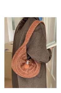 Caramel crochet hobo bag with wooden toggle closure and heart patch shown on a model