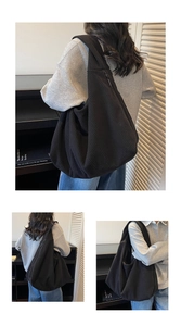 Détail de la texture en velours côtelé noir et de la fermeture éclair cachée du sac hobo