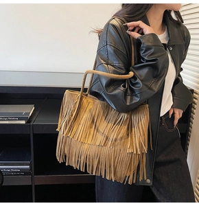 Détail d'un sac cabas marron en daim avec longues franges et style bohème chic