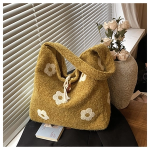 Close-up of mustard yellow plush tote bag with white flower embroidery and toggle closure