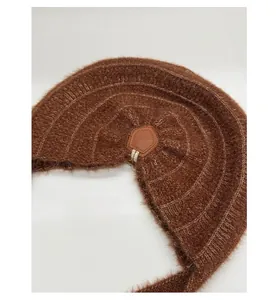 Detail view of coffee brown fuzzy knit fabric with pentagonal brown leather patch accent