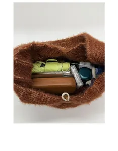 Top view of spacious brown knit tote showing storage for umbrella, glasses and phone
