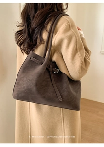 Detail view of large dark brown tote bag with suede texture and silver square buckle
