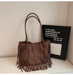 Détail du sac cabas en daim marron avec de longues franges et un style bohème vintage
