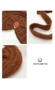 Detailed close-up of brown knit plush fabric with leather patch and fine stitching