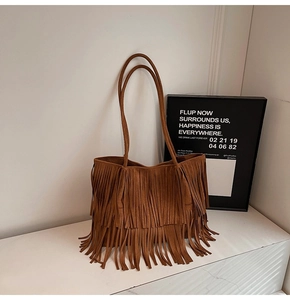 Détail d'un sac cabas en daim marron avec franges bohèmes à double couche et fines anses