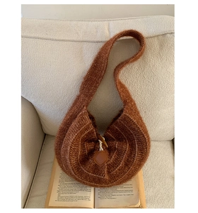 Macro view showing the wood horn buckle and leather loop on a brown plush shoulder bag