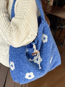 Blue plush tote bag with white flower embroidery and stylish toggle closure