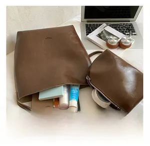 Detail of brown vintage leather tote set showing large capacity with phone and tablet