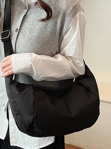 Minimalist black crescent crossbody bag with wide strap for casual daily use