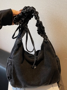 Retro black washed denim hobo bag with ruffled shoulder strap and bow drawstring details