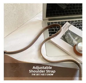 Detail of adjustable shoulder strap on brown vintage leather bag with fine stitching