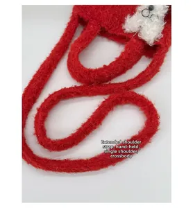 Detail view of red plush tote bag with extended straps and cute white puppy decor