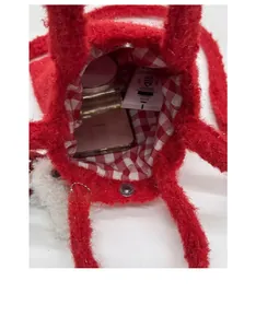 Detail showing red plush tote interior with vichy plaid lining and magnetic closure