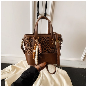 Detail of leopard print crossbody bag with wooden beads and embossed logo