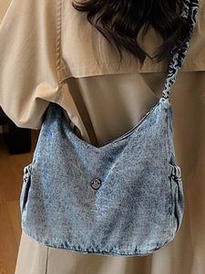 Retro washed denim hobo bag in blue with pleated shoulder strap and metal logo