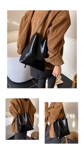 Detailed view of large black glossy tote bag with stylish shoulder straps for daily use