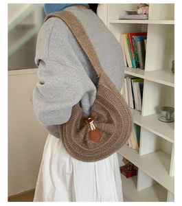 Detailed view of the brown knit shoulder bag texture with vintage horn buckle closure