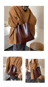 Detailed view of deep brown vintage leather tote bag shown on model in minimalist setting