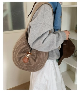 Detail of knitted hobo bag showing horn button closure and textured brown fabric