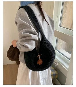 Detail of black faux fur hobo tote bag featuring a decorative toggle horn button closure