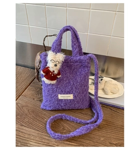 Detail of purple faux fur mini tote bag with cute dog pendant and brand label