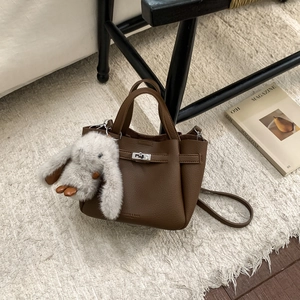 Détail du sac seau en cuir grainé marron foncé avec charmant lapin en peluche blanc