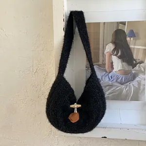 Detail of black faux fur shoulder bag with wooden horn buckle and brown leather charm