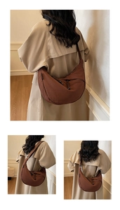 Detail of a brown nylon half-moon crossbody bag featuring textured fabric and zipper closure