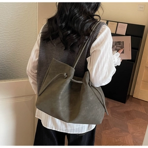 Close-up of vintage olive green tote bag featuring drawstring closure and matte texture