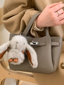Sac seau en cuir grainé gris avec fermoir en métal et breloque lapin sur manteau
