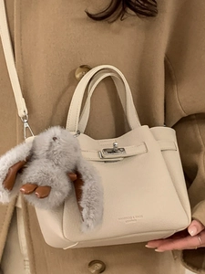 Sac seau élégant en cuir blanc cassé avec fermoir argenté et breloque lapin en peluche
