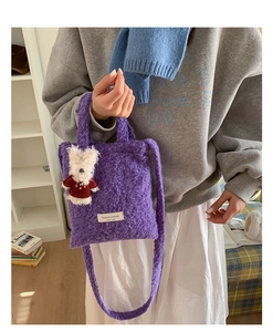 Detail view of purple plush tote bag texture with a cute bear charm and woven label