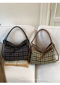Close-up of retro plaid tote bags with leather straps and metallic buckles on sofa