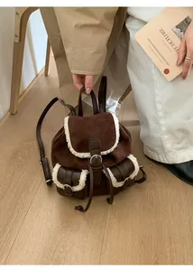 Detail of vintage brown suede backpack with white plush faux fur trim and buckle pockets