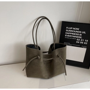 Detailed view of dark olive tote bag with matte texture and adjustable drawstring sides