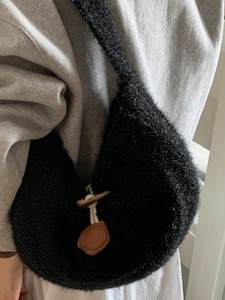 Large black plush shoulder tote bag with toggle closure for casual winter fashion styling