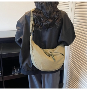 Detail view of large olive green hobo bag featuring a unique braided rope zipper puller