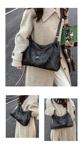 Detail of black faux leather hobo bag featuring white embroidery and woven chain strap