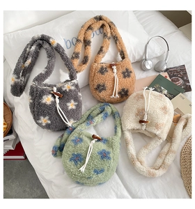 Detail of four colorful plush bucket bags with drawstring closure on white bedding background
