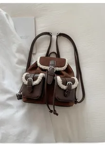 Detail of vintage suede backpack with plush faux fur trim and dual front pockets