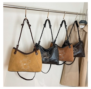 Macro detail of tote bags showing various colors and woven strap textures on a metal hanger