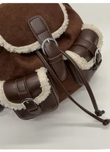 Detailed close-up of dual pocket backpack with faux fur trim and suede拼接 stitching