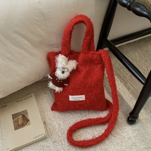 Close-up of red plush tote bag with fuzzy texture and cute white bunny charm