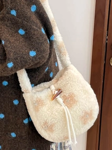 Retro plush bucket bag with brown flower patterns and horn buckle shown on model